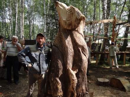 : 1 место:  Александр Парфенов, г. БарнаулНа «Праздник топора 2013» в г. Томск (вернее - с. Зоркальцево, 30 км от Томска) поехал за компанию с товарищем. Утром настроение улучшилось, когда встретил старых товарищей! А главное - вижу, лежит несколько кедровых бревен, самое большое из которых - с дуплом внутри! И никто на этот комель не покушается. Что с ним делать - с огромным, страшным? И действительно, что можно успеть сделать за 3,5 дня? Да еще при отпиливании бревна оказалось, что дупло - сквозное (вначале было не видно). Все советовали забить пустоту другой чуркой, а я поступил иначе: обыграл дупло, превратив шерсть на загривке медведя в елки, да сквозные! Как мне пригодилась для выпиливания просветов шина Carving!  И получился у меня -"Медведь-Тайга". И тайга продолжается и внутри медведя. Люди заглядывают в душу зверя-леса и видят таинственный нехоженый мир, в который не ступала нога человека. И стоит медведь на верхушках елок, и прижимает могучей хозяйской лапой лису - символ хитрости (чтоб сильно не шустрила). Так, из отвергнутого всеми бревна, с помощью любимой бензопилы STIHL получился нежданно-негаданно шедевр, повторение которого невозможно (где ж такое второе бревно найдешь?). А какие с помощью шины получаются ёлочки! STIHL - инструмент, дающий подсказки творчеству!  